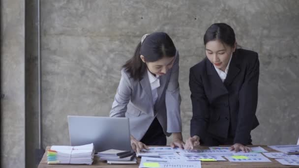 2人の美しいアジアのビジネス女性が交換の考え マーケティングおよび投資計画を分析する ノートパソコンを持ってデスクに座って書類作業を一緒にするビジネス協力の考え方 — ストック動画
