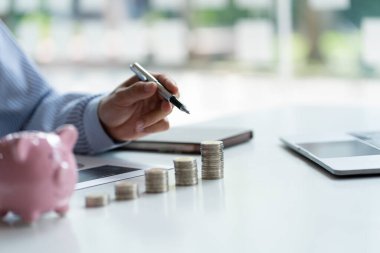 İyi Piggy Bank ve Yatırım Fikirleri veya İyi Tasarruf Şablonları Şirketi Büyümesi için Mali Planlama Metni için Finansal Analiz Alanını gösteren bir kalem tutan bir işadamı