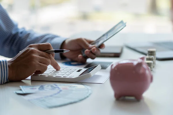 Financial planning at home in crisis. Man working. Home budget planning. Businessman holding pen and press calculator to calculate financial report.