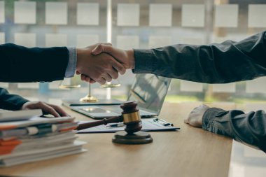 İş adamları ve avukatlar sözleşme belgelerini görüşmek için el sıkışıyorlar. İyi bir iş birliğinden sonra el sıkışma tavsiyesi. Erkek bir avukat ve önde çekiçli bir işadamı arasındaki danışma..