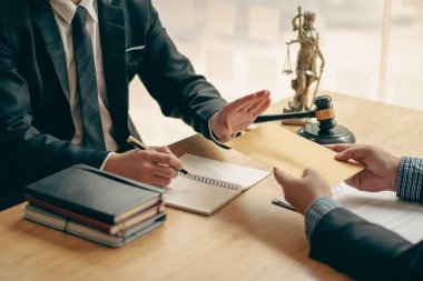 İş adamı ve avukat hukuki konuları tartışıyor ve hukuk bürosundaki bir takım toplantısında hakimin çekiciyle anlaşma imzalıyor..