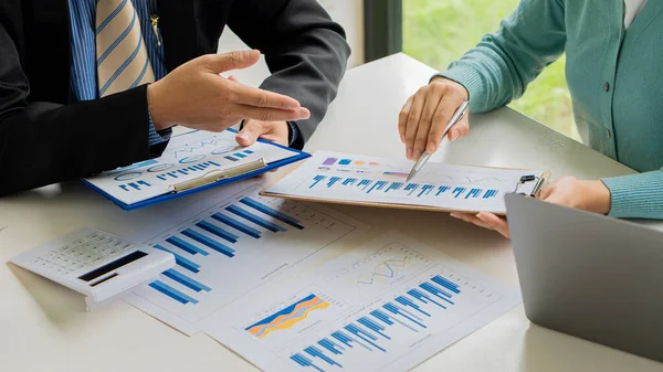 Business people meet with design ideas business planning Picture of two young businessmen holding pens and graph papers at a meeting discussing charts and graphs showing successful teamwork...