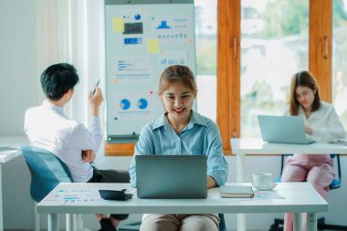 Asyalı ve Kafkasyalı şirket yöneticileri, üç genç iş adamı ve kadının ürün yol haritaları ve işbirliği fikirleri hakkında teknoloji girişimlerini tartıştığı bir konferans odasında iş konuşuyorlar..