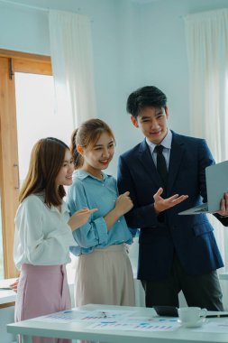 Asyalı ve Kafkasyalı şirket yöneticileri, üç genç iş adamı ve kadının ürün yol haritaları ve işbirliği fikirleri hakkında teknoloji girişimlerini tartıştığı bir konferans odasında iş konuşuyorlar..