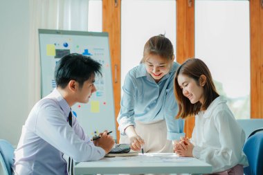 Asyalı ve Kafkasyalı şirket yöneticileri, üç genç iş adamı ve kadının ürün yol haritaları ve işbirliği fikirleri hakkında teknoloji girişimlerini tartıştığı bir konferans odasında iş konuşuyorlar..
