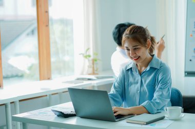 Genç ve güzel delikanlılar için birlikte çalışma kavramı. Finansal muhasebe, grafik, analiz ve hesaplama üzerinde çalışma. Ofisteki bir dizüstü bilgisayarla..