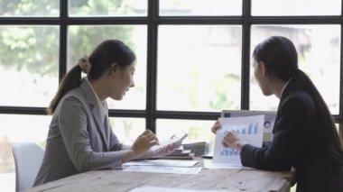 Asya 'daki iki genç iş kadını yeni bir belge projesi için iş arkadaşlarıyla beyin fırtınası yapıyor. Başarının stratejilerini planlamak için birlikte çalışan küçük bir ofiste ekip olarak çalışmanın tadını çıkarın..