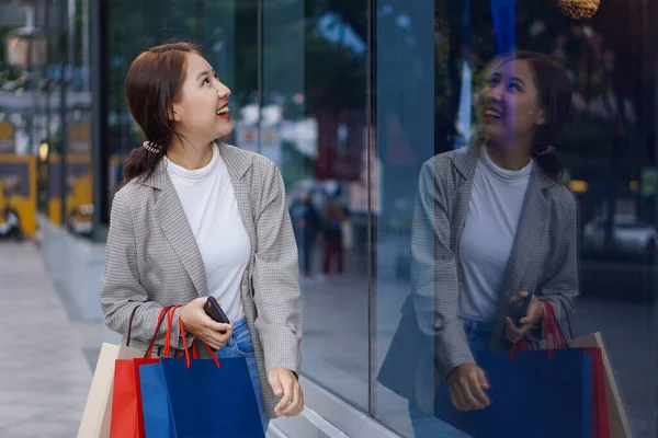 在购物中心里的一家百货商店的地板上 带着购物袋笑着的亚洲女人 妇女时尚 生活方式 销售和人的观念 — 图库照片