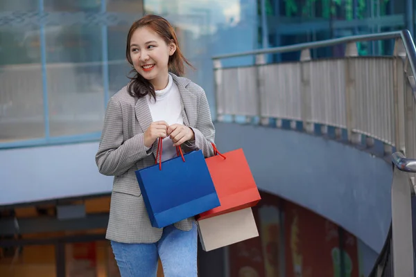 在购物中心里的一家百货商店的地板上 带着购物袋笑着的亚洲女人 妇女时尚 生活方式 销售和人的观念 — 图库照片