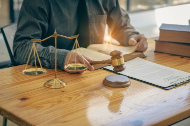 İş avukatları masalarında kitap ve kağıtlarla sıkı çalışırlar. Yargıç, adalet avukatına çekiç kullanıyor. Avukatlık Bürosu Adalet Tanrıçası ve kanun terazisi. tavsiye 