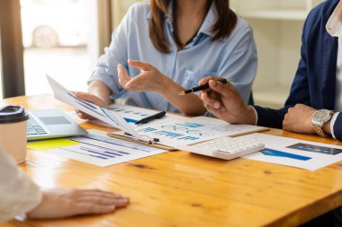 İki işadamı mali bütçe veya maliyet şirketlerinin grafik raporlarını ve analizini tartıştı. Ofisteki hesap makinesini kullanarak bir iş stratejisi üzerinde fikir alışverişinde bulunmak için iş arkadaşlarıyla buluşacağım..