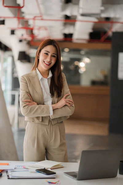 Asian businesswoman working on laptop computer in office with documents on desk woman looking at financial statistics data analysis chart profit growth business idea vertical image