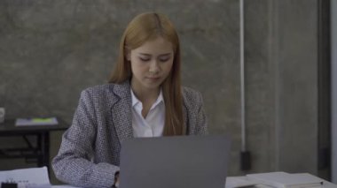 İş kadını finans danışmanı modern bir ofiste çalışan bir dizüstü bilgisayarla finansal tabloları analiz ediyor. İş kadını iş kurma fikrine uygun