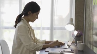 İş kadını finans danışmanı modern bir ofiste çalışan bir dizüstü bilgisayarla finansal tabloları analiz ediyor. İş kadını iş kurma fikrine uygun