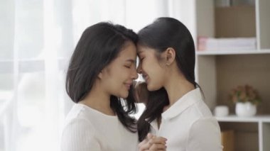 LGBTQ lezbiyen ve homoseksüel kadınlar el ele tutuşup birbirlerine sevgiyle bakıyorlar. Mutlu gülümseme Transseksüel çiftler. Çift Eşitliği, LGBTQ + Konsepti