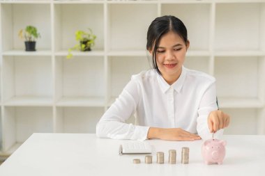 Para biriktirmek ve tasarruf planı yapmak için para dolu bir kavanozda para tutan gülümseyen Asyalı kadın. Gelecekteki büyüme kişisel ekonomi sektörü ve finansal kavramlar