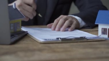 Yavaş çekim video 4k iş adamları bir ev emlak konsepti satın almak için imza atıyorlar