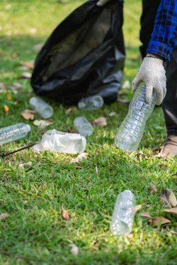 Genç bir adam plastik şişeleri ve siyah poşetleri topluyor ve onları geri dönüşüm için toplayanlara satmak üzere biraraya getiriyor. Atık ayırma ve çevre koruma kavramı