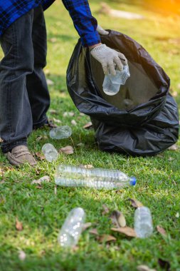Genç bir adam plastik şişeleri ve siyah poşetleri topluyor ve onları geri dönüşüm için toplayanlara satmak üzere biraraya getiriyor. Atık ayırma ve çevre koruma kavramı