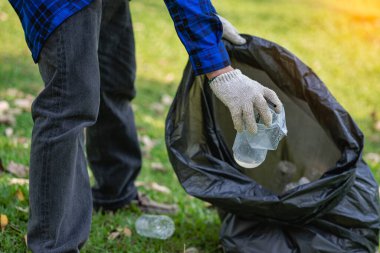 Genç bir adam plastik şişeleri ve siyah poşetleri topluyor ve onları geri dönüşüm için toplayanlara satmak üzere biraraya getiriyor. Atık ayırma ve çevre koruma kavramı