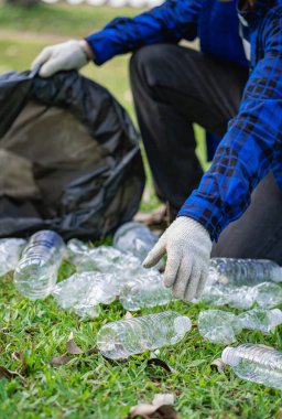Genç bir adam plastik şişeleri ve siyah poşetleri topluyor ve onları geri dönüşüm için toplayanlara satmak üzere biraraya getiriyor. Atık ayırma ve çevre koruma kavramı