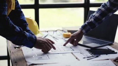 Mimarlar ve mühendisler anlaşmadan sonra el sıkışıyor ve toplantı sonrasında onları tebrik ediyorlar. Bu, her iki partinin de ofisteki birlik ve takım çalışmasının iş arkadaşlığını simgeliyor..