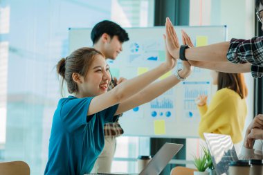 Gelişigüzel giyinen bir grup yaratıcı Asyalı ofis projelerinin başarısını kutlamak için el ele tutuşuyor. Başlangıçta birçok erkek ve kadın birlikte durdu. Meslektaşların takım çalışması kavramı