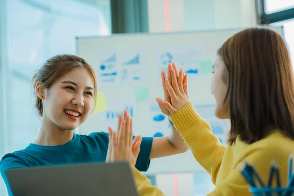 A group of creative young Asians in casual wear join hands to celebrate the success of their office project. Many men and women stood together at the beginning. teamwork concept of colleagues