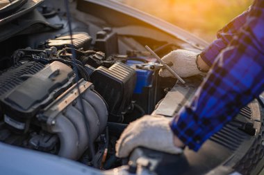 Teftiş aracının önünde duran Asyalı adam evdeki araba motorundaki makine sorunlarını inceliyor ve arabanın içinde tamir edilecek sorunlar buldu. Asyalı bir adamın araba motoru var.