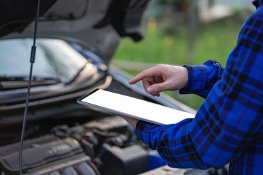 Teftiş aracının önünde duran Asyalı adam evdeki araba motorundaki makine sorunlarını inceliyor ve arabanın içinde tamir edilecek sorunlar buldu. Asyalı bir adamın araba motoru var.