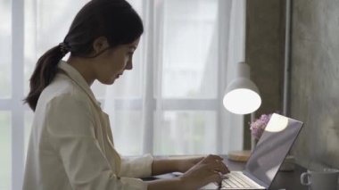 Finansal grafik belgeleriyle çalışan Asyalı kadın muhasebeci, çizelgeler için vergileri hesaplıyor ve ev gelirlerinin grafiklerini çıkarıyor. Dizüstü bilgisayarda çalışan ve harcama bütçesi planlayan iş kadını.
