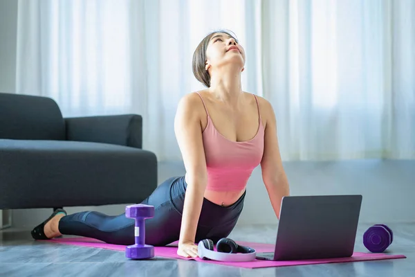 Smiling Asian Woman Doing Shoulder Stretching Yoga Online Class Laptop — Stockfoto