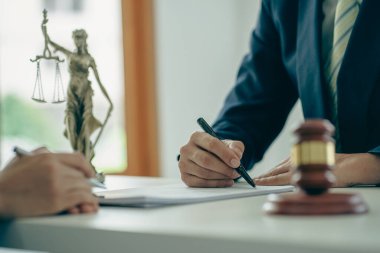 Erkek avukatlar ya da hakimler, müşteriler, iş ve hukuki hizmetler için ekiplere danışırlar. Danışman, adalet ve avukat kavramının önüne konan çekiçle imzalanan sözleşmeyi sunar.