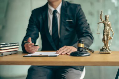 Hukuk bürosu avukatları çekiçlerle ve kontrat belgeleriyle danışmanlık masasında yasal kaplan derileriyle çalışıyorlar..