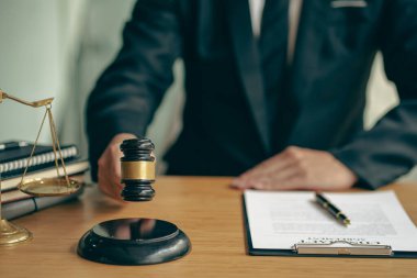 Hukuk bürosu avukatları çekiçlerle ve kontrat belgeleriyle danışmanlık masasında yasal kaplan derileriyle çalışıyorlar..