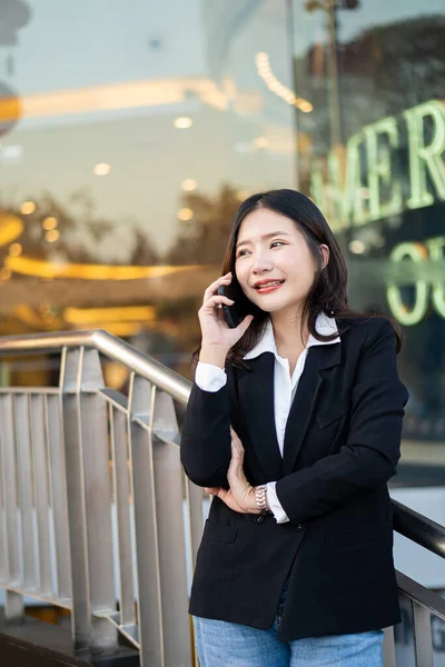 在外面工作的亚洲女商人用智能手机看商业区的屏幕 坐在外面的职业女性 — 图库照片