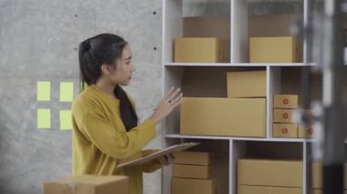 Bir KOBİ başlatın, kutulu laptop kullanan bağımsız Asyalı kadınlardan oluşan küçük bir girişimci. neşeli başarı Online pazarlama paketleme kutuları üzerinde çalışan kadın ve KOBİ konseptleri 4k video teslim