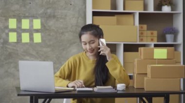 Bir KOBİ başlatın, kutulu laptop kullanan bağımsız Asyalı kadınlardan oluşan küçük bir girişimci. neşeli başarı Online pazarlama paketleme kutuları üzerinde çalışan kadın ve KOBİ konseptleri 4k video teslim