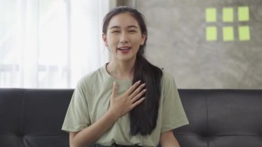 Asyalı bir kadının yurt dışındaki iş arkadaşlarıyla görüntülü konuşma teknolojisini kullanması. Sosyal uzaklık 4k videosu ile sohbet et