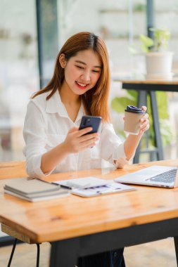 Asyalı iş kadını bir kafede akıllı telefon ile konuşuyor. Masaüstü girişimi, işi, asya, kadın, internet, KOBİ, tele pazarlama, dikey fotoğraf..
