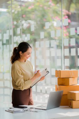 Küçük bir işletme KOBİ işletme sahipleri kurmak, başarılı kadın girişimciler kutularla dizüstü bilgisayarlarla çalışmak ve kutuları hazırlamak için online siparişleri işaretlemek. Müşterilere ve KOBİ iş fikirlerine satış.