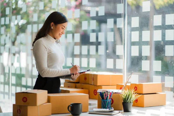 start a small business SME business owners, successful female entrepreneurs Work with laptops with boxes and check online orders to prepare boxes. Selling to customers, SME business ideas.