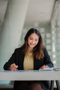 Modern ofiste dizüstü bilgisayar kullanan Asyalı iş kadını mali grafikler ve emlak yatırım verileriyle muhasebe analizi yapıyor. finansal ve vergi sistemi kavramları