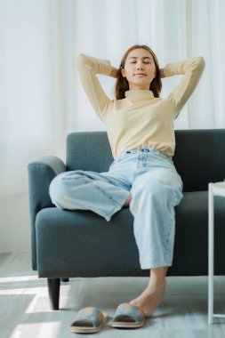 Güzel Asyalı kadın kanepede dinleniyor ve uyuyor.