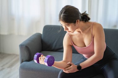 Evde yoga yapan güzel bir Asyalı kadın. Oturma odasında omuzlarına sağlıklı bir gülümseme geriliyor. Geniş bir pencerenin yanında tüm vücut portresi, spor ve sağlıklı yaşam tarzı kavramları.