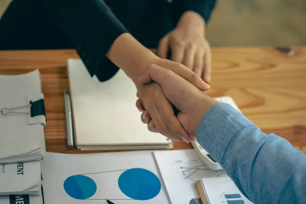 Close-up of business people shaking hands. End of meeting. Business etiquette. congratulations merger concept A businessman accepts or confirms a project as an offer and shakes hands at the office.