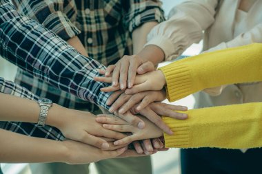 Bir grup iş adamı yaratıcı ofiste el sıkışıyor, genç bir takım koordinatları ve el sıkışıyor, işbirliği, takım çalışması konsepti.