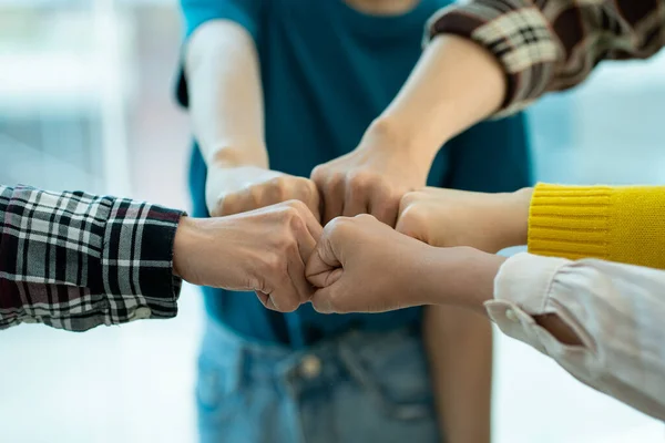 Young business team standing together, volunteers, charity, people working together for business success. caring teamwork partnership And social connections in business go hand in hand.