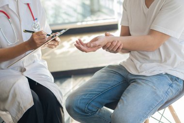 Doktorlar klinikteki hastalarla konuşur. Steteskop, hasta konsültasyonları ve teşhisleri üzerinde yoğunlaşıyoruz. Oturup konuşuyoruz. Hastane medikal konseptinde pencerenin yanındaki masada.