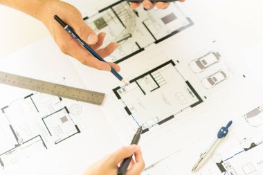 Bir grup mühendis ve mimar binanın inşasını tartışıyor. İnşaat ofisindeki masanın üzerinde planlar ve konferans odasında yeni bir proje planlamak..